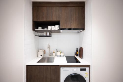 a kitchen with a sink and a washing machine at ryeoan seomyeon in Busan