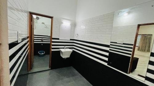 a bathroom with black and white stripes on the wall at Mountain Breeze Neyyans in Attappādi