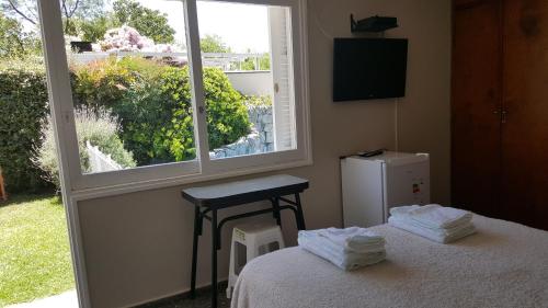 1 dormitorio con cama, ventana y TV en Tabanera suite en Mendoza