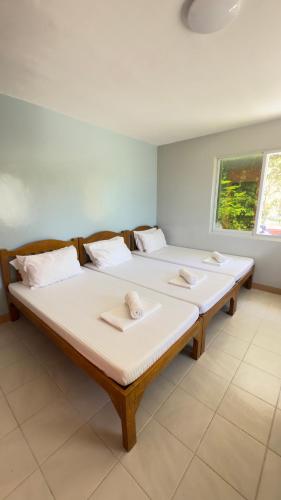 two beds in a room with two pillows on them at Bantayan Beachfront Seacamp Okoy Private House Operated by In Dai Aquasports and Beach Resort in Bantayan Island