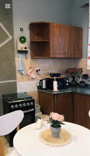 a kitchen with a stove and a table with a tableablish at Malaika homes in Kampala