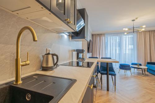 a kitchen with a sink and some blue chairs at Azure Mostek Oldtown in Gdańsk