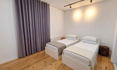 a room with two beds and a window with curtains at Villa Fratello in Baku