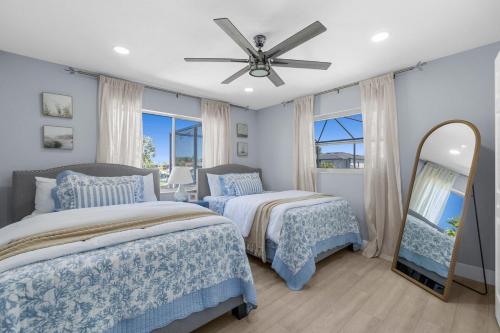 a bedroom with two beds and a ceiling fan at Waterfront Oasis in Cape Coral