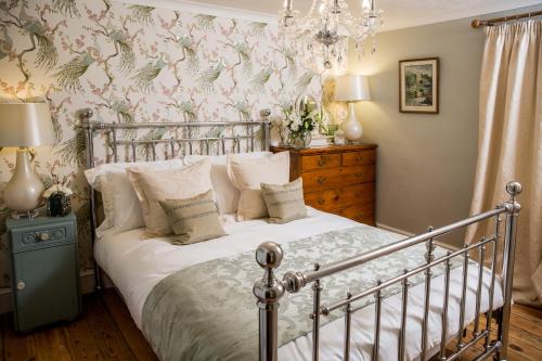 um quarto com uma cama e um lustre em No61 Winchcombe (Cotswolds) em Winchcombe