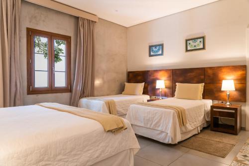 a hotel room with two beds and a window at Hotel Boutique Las Hortensias in Pilar
