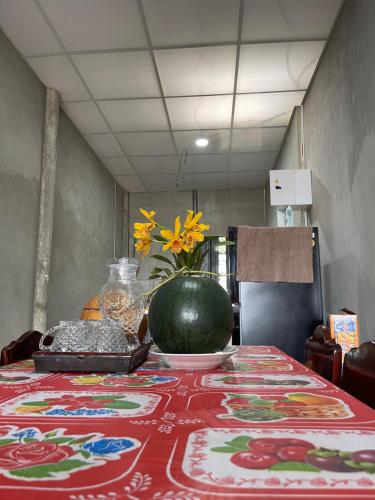 a table with a vase of flowers on top of it at Vùng ven Homestay in Cho Lach
