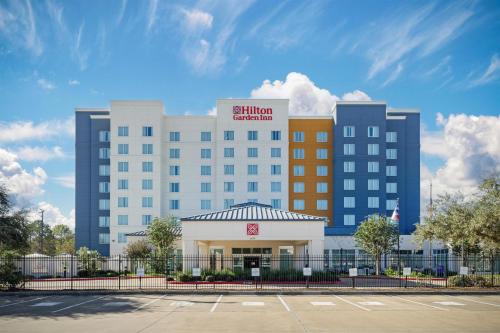 a hotel building with a parking lot in front of it at Hilton Garden Inn Houston NW America Plaza in Houston