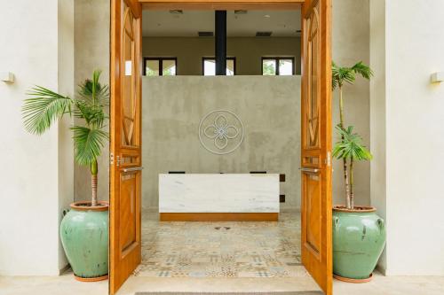 a lobby with two palm trees in large vases at Hotel Boutique Las Hortensias in Pilar