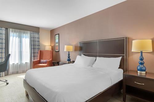 a hotel room with a large bed and a chair at Hilton Garden Inn Houston NW America Plaza in Houston