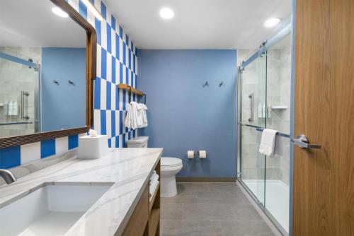 a bathroom with a toilet and a glass shower at Home2 Suites by Hilton Outer Banks Kill Devil Hills in Kill Devil Hills
