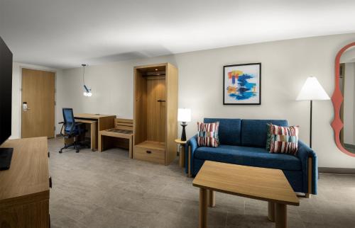 a living room with a blue couch and a table at Home2 Suites by Hilton Outer Banks Kill Devil Hills in Kill Devil Hills