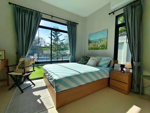 a bedroom with a bed and a large window at Mango Villa แมงโก้ วิลล่า in Sa Kaeo