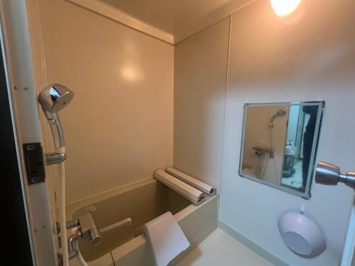 a small bathroom with a mirror and a sink at 旭川ロキ in Asahikawa
