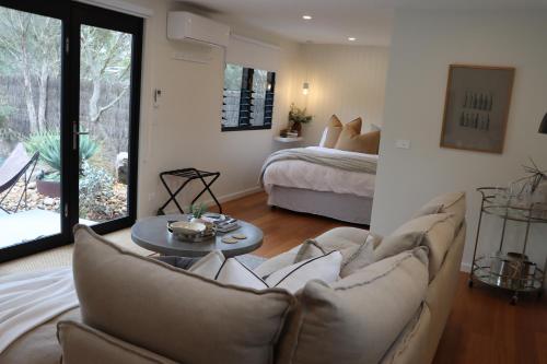 a living room with a couch and a bed at Driftwood Studio in Mount Martha