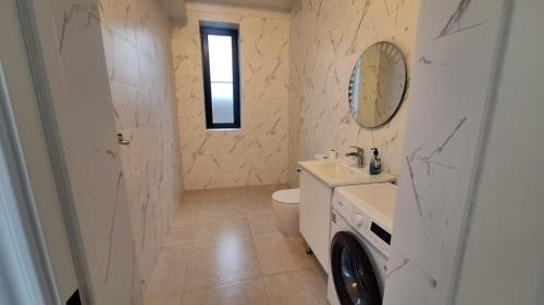 a bathroom with a toilet and a sink and a mirror at Villa Fratello in Baku