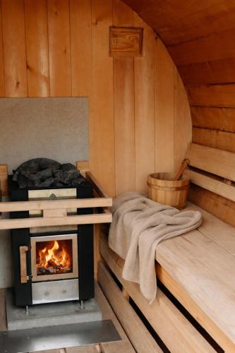 a room with a stove and a bed in a cabin at Bohemian Wellness met hottub & sauna in Ewijk