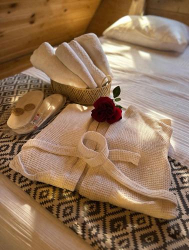 a white towel with a rose on a bed at Tasia's Cottage in Tsalka