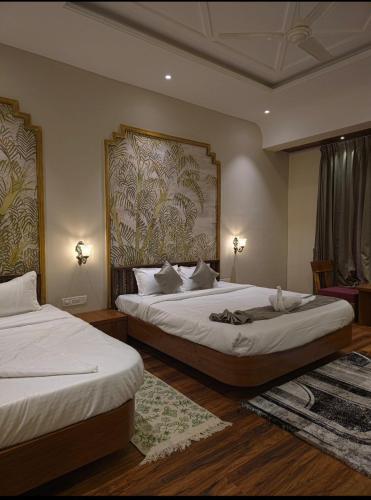 a bedroom with two beds and a painting on the wall at Miransh Heavenly in Dapoli
