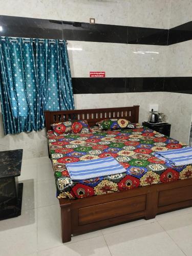 a bedroom with a bed with a comforter on it at HAnsHari Homestay in Kuttālam