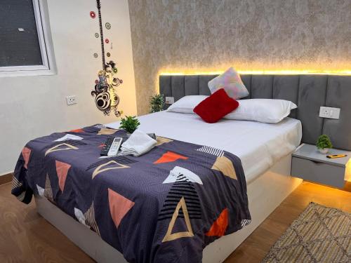a bedroom with a large bed with a colorful blanket at Quantum stay 1 BHK couples family corporate in Noida