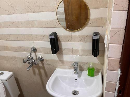 a bathroom with a sink and a mirror and a toilet at Quantum stay 1 BHK couples family corporate in Noida