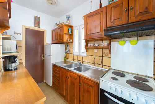 a kitchen with wooden cabinets and a stove top oven at Villa Lia Panorama in Pefki Rhodes