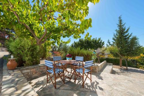 a table and chairs with a tree in a yard at Villa Lia Panorama in Pefki Rhodes