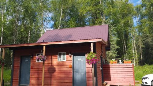 uma pequena cabina de madeira com um telhado roxo em DFA Cabin Rentals em Talkeetna