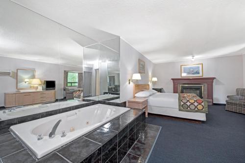 um quarto de hotel com uma grande banheira e uma cama em Super 8 by Wyndham Niagara Falls North em Cataratas do Niágara