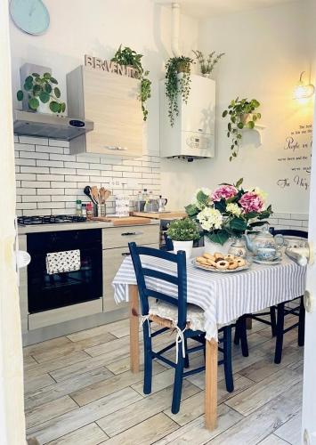 a kitchen with a table with a blue chair at Suite La Corte in Florence