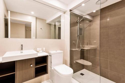 a bathroom with a shower and a toilet and a sink at Quality Hotel Manor in Mitcham