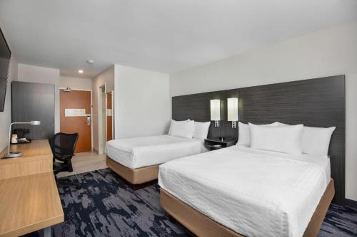 a hotel room with two beds and a desk at Quality Inn & Suites in Winnipeg