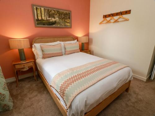 a bedroom with a bed with two lamps and a painting on the wall at Clocktower - Culzean Castle in Maybole