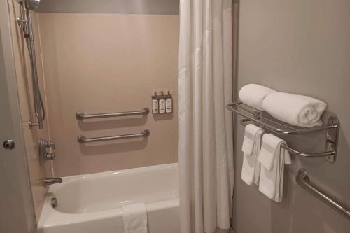 a bathroom with a shower and a bath tub with towels at Comfort Inn & Suites Miami - Route 66 in Miami