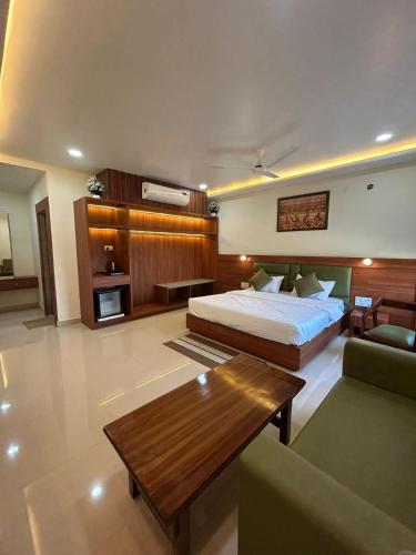 a bedroom with a bed and a couch and a table at Hotel Sunrise in Damoh