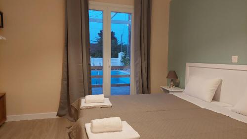 a bedroom with a bed with two towels on it at Amelia's Garden ΙΙ in Kavos