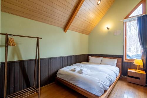 a bedroom with a bed with two teddy bears on it at Goodfellas Onsen House in Niseko