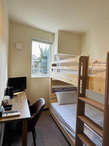 a room with bunk beds and a desk with a computer at HAOSTAY Eirin in Fujikawaguchiko