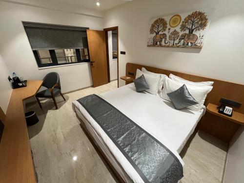 a hotel room with a bed and a desk at Mastiff Hotel Crystara, Jalgaon in Jālgaon