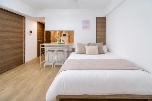 a bedroom with a large bed and a kitchen at 801Room,Sky Tower 12 minutes walk Sensoji Temple 15 minutes walk New Apartment 50 m2 direct access to Haneda Airport in Tokyo