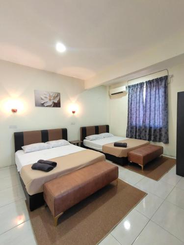 a bedroom with two beds and a window at D'Aleena Inn Kodiang in Kodiang
