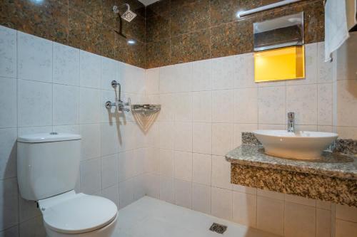 a bathroom with a toilet and a sink at Hotel Peaceland Lumbini in Rummindei