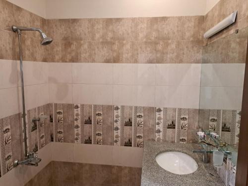 a bathroom with a sink and a shower at Cuzzy Inn Stay in Lahore