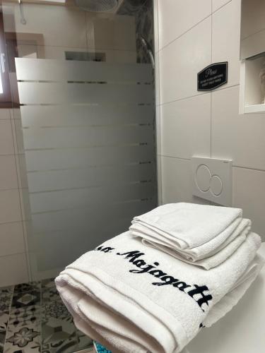 a pile of towels sitting on a shelf in a bathroom at Casa Majagatt Holiday Home in Roveredo