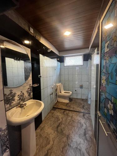 a bathroom with a sink and a toilet at Maria Ceylon Villa in Tangalle
