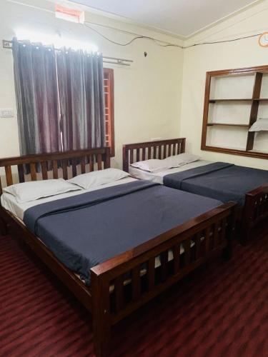 two twin beds in a bedroom with a window at Villa Mountain Pearl in Chikmagalūr