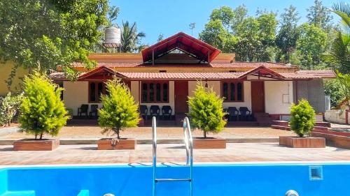 a house with a swimming pool in front of it at Villa Mountain Pearl in Chikmagalūr