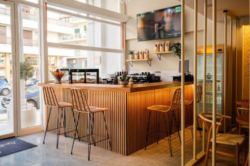 a restaurant with a bar with chairs around it at Aether Athens Urban Hotel in Athens