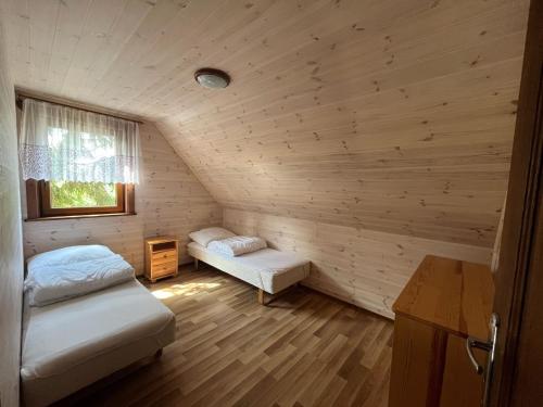 a room with two beds and a window at Domki Vesper Międzywodzie in Międzywodzie